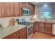 Well-lit kitchen with stainless steel appliances, granite countertops, and dark wooden cabinets at 126 N Barton St, Norcross, GA 30071