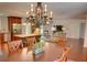 Open concept living room and dining area with a large chandelier, kitchen island, and stainless steel appliances at 126 N Barton St, Norcross, GA 30071