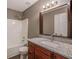 Bathroom features granite countertop, wood cabinets, and a tub with a shower head at 1526 Venetian Sw Dr, Atlanta, GA 30311