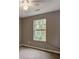 Cozy bedroom featuring a large window, neutral walls, and plush carpet at 1526 Venetian Sw Dr, Atlanta, GA 30311