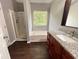 Main bathroom featuring dual sinks, granite countertops, walk-in shower, and a bathtub at 1526 Venetian Sw Dr, Atlanta, GA 30311