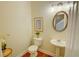 Powder room features a pedestal sink and decorative mirror and light fixture at 2557 Avery Park Cir, Atlanta, GA 30360