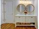 Stylish bathroom vanity with double sinks, round mirrors, and decorative storage baskets at 2557 Avery Park Cir, Atlanta, GA 30360