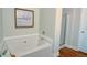 Bright bathroom featuring a soaking tub with tile surround and a separate glass-enclosed shower at 2557 Avery Park Cir, Atlanta, GA 30360
