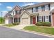 Street view of charming townhomes with garages, well-kept lawns, and inviting red doors at 2557 Avery Park Cir, Atlanta, GA 30360