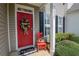 Welcoming red front door adorned with a floral wreath and a charming decorative chair at 2557 Avery Park Cir, Atlanta, GA 30360