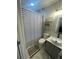 Updated bathroom showcasing a shower with a striped curtain, floating shelves, and a vanity sink at 3009 Bruce Nw Ct, Acworth, GA 30101