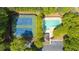 Overhead view of the community pool, tennis courts, and parking area surrounded by lush trees at 5395 Fontenoy Ct, Peachtree Corners, GA 30071