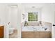 Bright bathroom showcases a soaking tub with tile surround and a window at 5395 Fontenoy Ct, Peachtree Corners, GA 30071