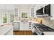 Well-lit kitchen features stainless appliances, white cabinets, and tile backsplash at 5395 Fontenoy Ct, Peachtree Corners, GA 30071