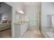 Bright and well-designed bathroom featuring marble countertops, double sink vanity, bathtub, and stand-up shower at 2794 Kakki Ct, Marietta, GA 30062