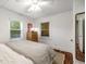 Bright bedroom with hardwood floors, a ceiling fan, two windows, and a comfortable bed with striped blanket at 324 Pine Ne St, Marietta, GA 30060