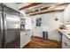 Modern kitchen with stainless steel refrigerator, white cabinets, granite counters, and exposed wood beams at 324 Pine Ne St, Marietta, GA 30060