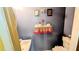 Compact bathroom featuring blue walls and unique decor including a shelf with floral arrangements at 4256 Village Square Ln, Stone Mountain, GA 30083