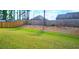 A verdant grassy backyard with a partial wood fence for a serene outdoor space at 632 Eagles Nest Cir, Auburn, GA 30011