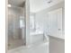 Bathroom featuring a glass-enclosed shower, soaking tub, and a pristine white vanity at 632 Eagles Nest Cir, Auburn, GA 30011