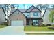 Charming two-story home featuring a brick facade, manicured lawn, and attached two-car garage at 632 Eagles Nest Cir, Auburn, GA 30011