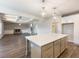 Spacious open-concept kitchen with an island overlooking the living area and brick fireplace at 632 Eagles Nest Cir, Auburn, GA 30011