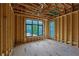 Exposed framing in the unfinished primary bedroom with large windows overlooking the yard at 120 Wood River Ct, Johns Creek, GA 30097