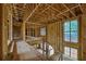 Interior view of a home under construction, showing wood framing and large window elements at 120 Wood River Ct, Johns Creek, GA 30097