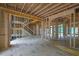 Unfinished living room featuring exposed wood beams, a staircase, and large windows at 120 Wood River Ct, Johns Creek, GA 30097