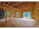 Living room during construction showcasing framing, utility board and large windows for natural light at 120 Wood River Ct, Johns Creek, GA 30097