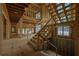 Unfinished staircase leading to the second floor with exposed wood and a view of the entrance at 120 Wood River Ct, Johns Creek, GA 30097