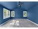 Bright bedroom featuring gray carpet, blue walls, vaulted ceilings, and multiple windows at 1421 Smith Se St, Atlanta, GA 30316