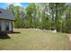 View of the backyard featuring a rock wall border with an expansive lawn and a treeline providing privacy at 247 Terrace View Dr, Acworth, GA 30101