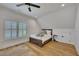 Finished attic bedroom with ceiling fan, hardwood floors, natural light, and a small wardrobe at 247 Terrace View Dr, Acworth, GA 30101