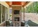 Outdoor patio featuring a brick fireplace, ceiling fan, and seating area with a view of the wooded backyard at 247 Terrace View Dr, Acworth, GA 30101