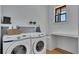 Well-lit laundry room with modern washer and dryer, built-in counter space, floating shelves, and a bright window at 247 Terrace View Dr, Acworth, GA 30101