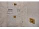Elegant shower featuring white marble tiles, gold fixtures, and convenient built-in shelving for a spa-like experience at 247 Terrace View Dr, Acworth, GA 30101