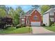Traditional brick home with an attached two-car garage, manicured lawn, and mature trees at 370 Landing Entry, Johns Creek, GA 30022