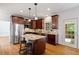 A kitchen featuring wooden cabinets, stainless steel appliances, and a granite island with seating at 370 Landing Entry, Johns Creek, GA 30022