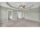 Primary bedroom featuring a ceiling fan, trey ceiling, carpeted floors, and connected bathroom at 14807 Highway 36, Covington, GA 30014