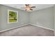 Neutral bedroom featuring a ceiling fan, green walls, carpeted floor, and a sunlit window at 14807 Highway 36, Covington, GA 30014