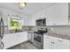 Updated kitchen with modern appliances, white cabinetry, and laminate countertops at 14807 Highway 36, Covington, GA 30014