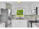 Bright kitchen features a stainless steel refrigerator and view to the backyard at 14807 Highway 36, Covington, GA 30014