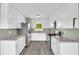 Galley kitchen with modern stainless steel appliances and white cabinets at 14807 Highway 36, Covington, GA 30014
