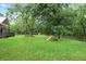 Well-maintained backyard featuring a lush green lawn, mature trees, and play equipment at 1830 Lost Mountain Rd, Powder Springs, GA 30127