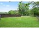 A spacious backyard area featuring a wood privacy fence and a chain link fence, bordering the property at 1830 Lost Mountain Rd, Powder Springs, GA 30127