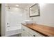 Bathroom featuring neutral walls, a modern vessel sink, a wood countertop, and shower-tub combo at 1830 Lost Mountain Rd, Powder Springs, GA 30127