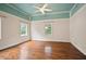 View of the bedroom with hardwood floors, multiple windows, ceiling fan and painted wood ceiling at 1830 Lost Mountain Rd, Powder Springs, GA 30127