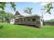 Charming home exterior with a covered porch, metal roof, and well-maintained lawn at 1830 Lost Mountain Rd, Powder Springs, GA 30127