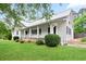 Charming home featuring a metal roof, white siding, front porch, and well-maintained landscaping at 1830 Lost Mountain Rd, Powder Springs, GA 30127