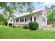 Charming two-story home boasts a white exterior, metal roof, inviting front porch, and lush green lawn at 1830 Lost Mountain Rd, Powder Springs, GA 30127