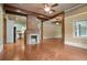 Open living room with wood floors, wooden beams, fireplace, and open access to kitchen at 1830 Lost Mountain Rd, Powder Springs, GA 30127