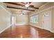 Open living room featuring hardwood floors, wood-beamed ceilings, and lots of natural light at 1830 Lost Mountain Rd, Powder Springs, GA 30127
