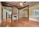 View of the living room, exposed brick fireplace, and connecting kitchen area with white cabinets at 1830 Lost Mountain Rd, Powder Springs, GA 30127